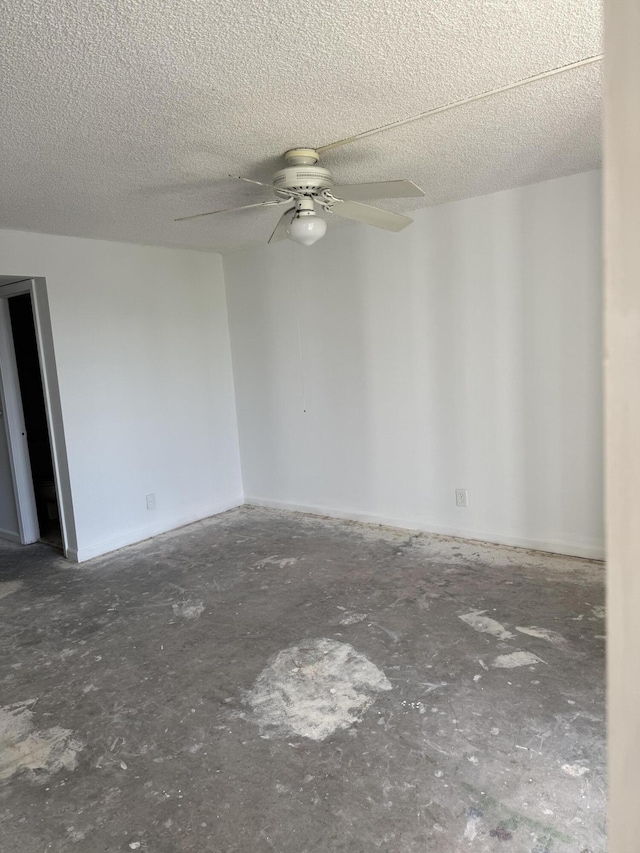 unfurnished room with ceiling fan and a textured ceiling