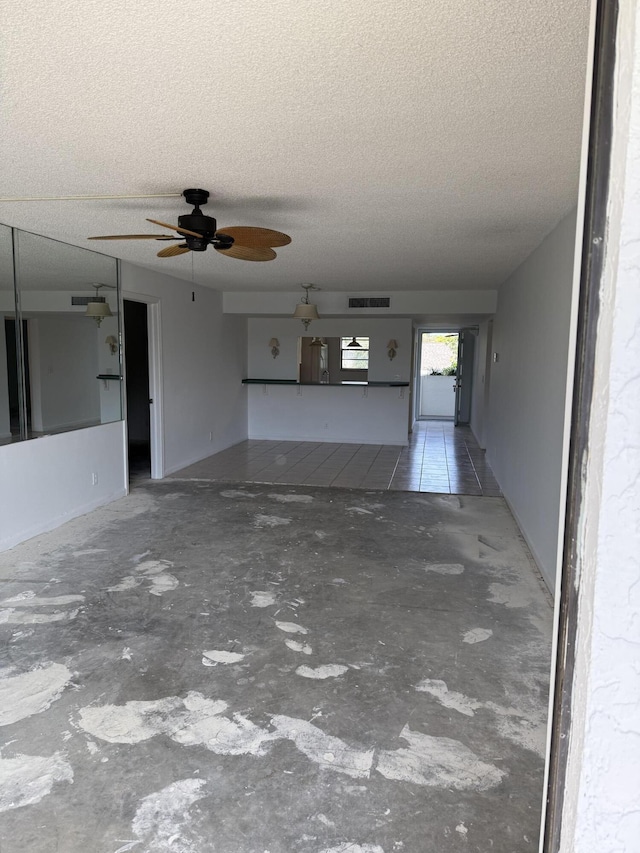 unfurnished living room with concrete flooring, visible vents, and a textured ceiling