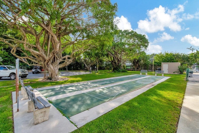 surrounding community featuring shuffleboard and a lawn