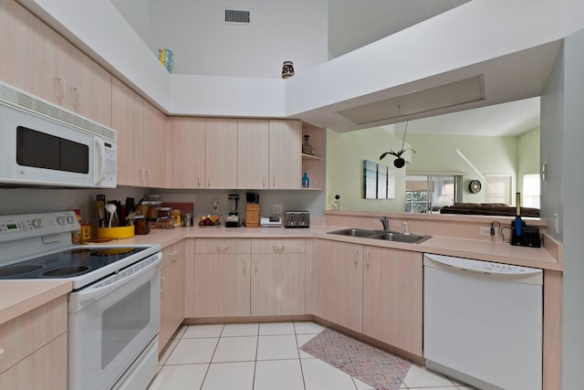 kitchen with sink, light brown cabinets, white appliances, and light tile patterned floors