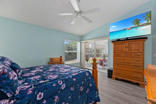 bedroom with ceiling fan, lofted ceiling, a textured ceiling, and light hardwood / wood-style floors