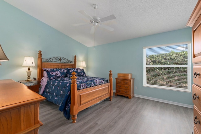 bedroom featuring hardwood / wood-style flooring, ceiling fan, lofted ceiling, and a textured ceiling