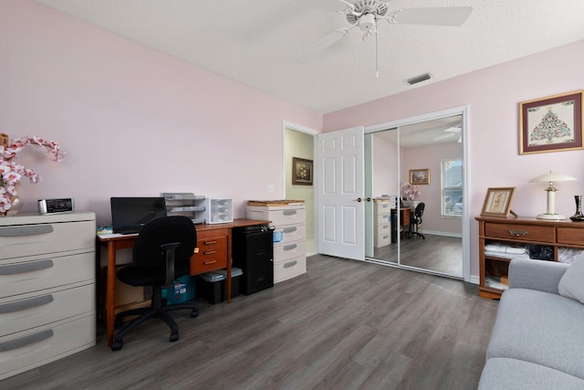 office space featuring a textured ceiling, dark wood-type flooring, and ceiling fan