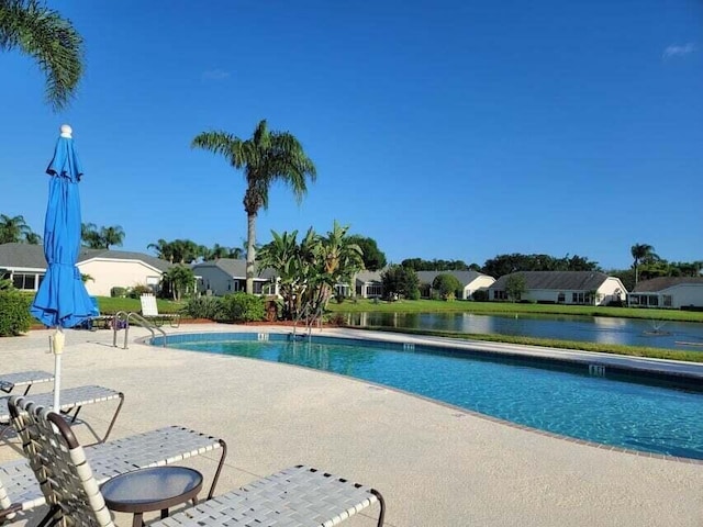 view of pool featuring a patio and a water view