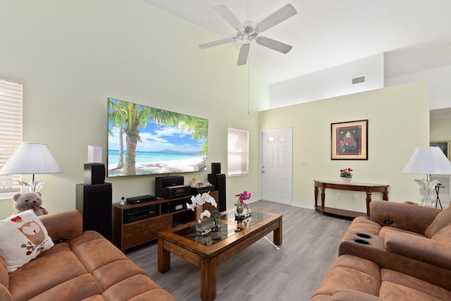 living room featuring ceiling fan, high vaulted ceiling, and light wood-type flooring