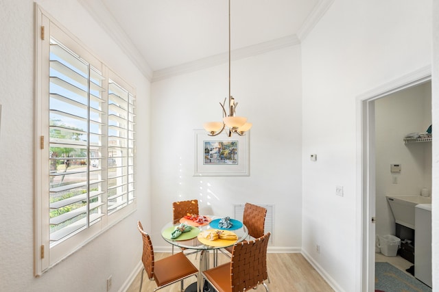 dining area with ornamental molding, a chandelier, and light hardwood / wood-style floors