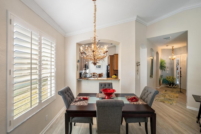 dining space featuring an inviting chandelier, crown molding, and light wood-type flooring