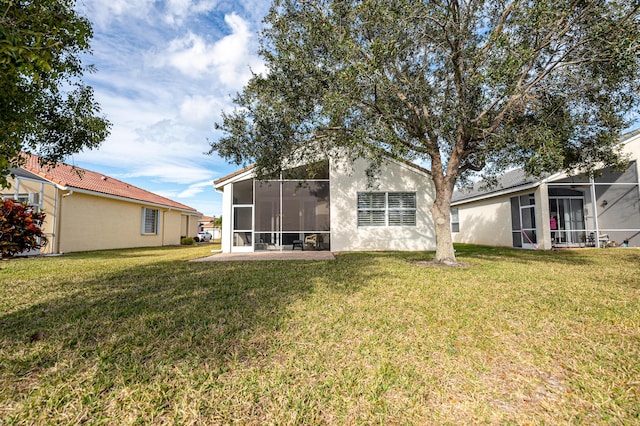 back of property with a lawn and a patio area