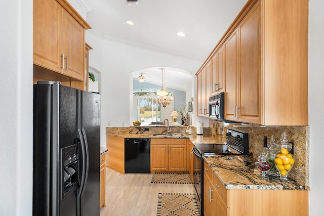 kitchen with stone countertops, sink, black appliances, crown molding, and light hardwood / wood-style flooring