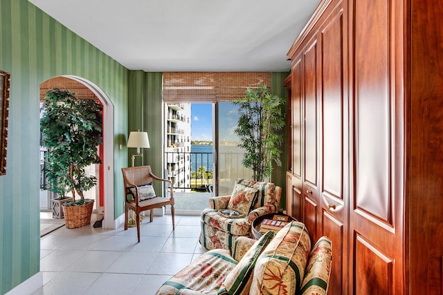 sitting room featuring a water view and light tile patterned flooring