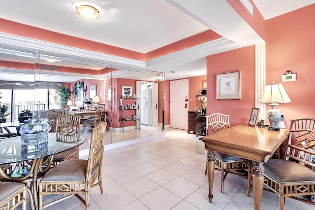 dining room featuring light tile patterned floors and a tray ceiling