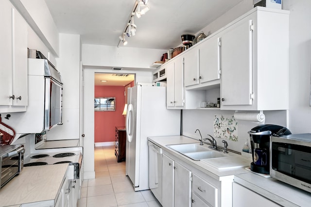 kitchen featuring white cabinetry, sink, white appliances, and light tile patterned floors