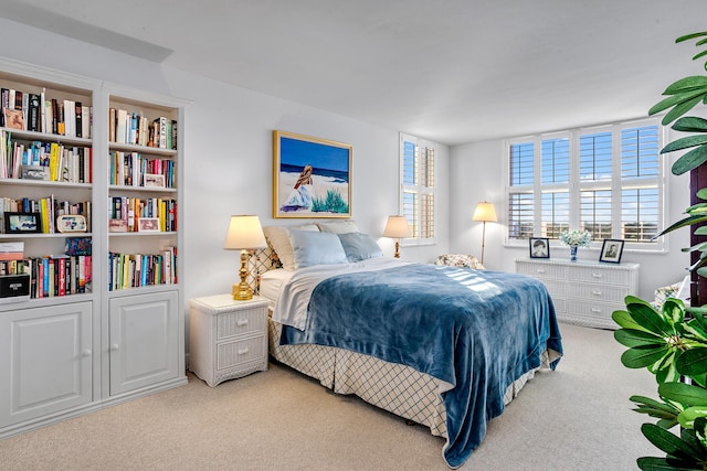 bedroom with light colored carpet and multiple windows