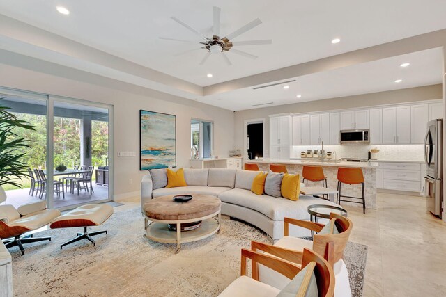 kitchen with sink, stainless steel appliances, white cabinets, and a center island with sink