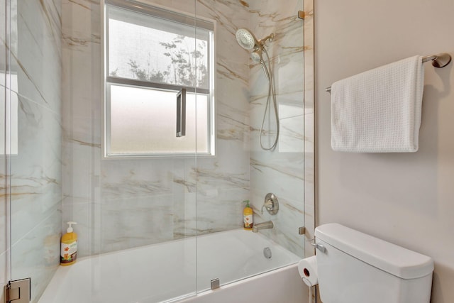 bathroom with toilet and combined bath / shower with glass door