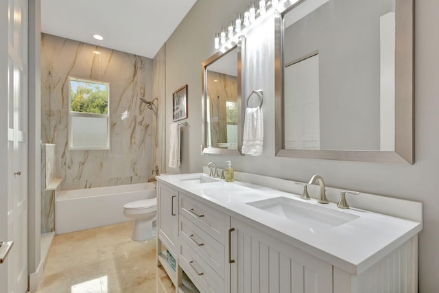 full bathroom featuring tiled shower / bath, vanity, and toilet