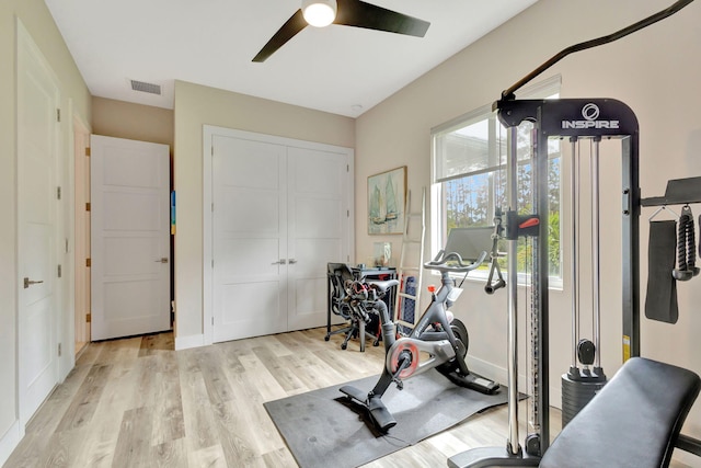 workout area featuring light wood-type flooring and ceiling fan