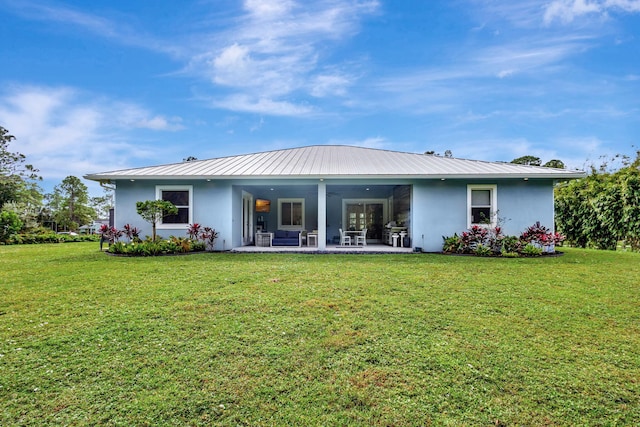 rear view of property with a yard and a patio area