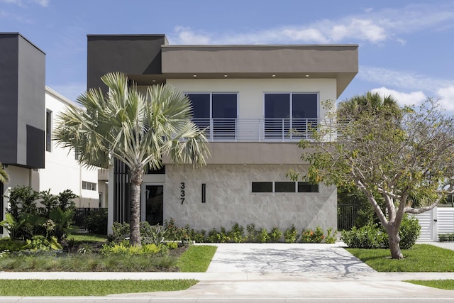 contemporary home featuring a balcony and stucco siding