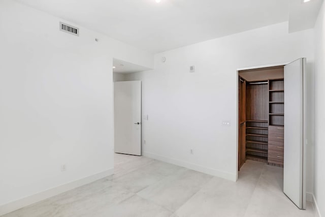 unfurnished bedroom featuring a walk in closet and a closet