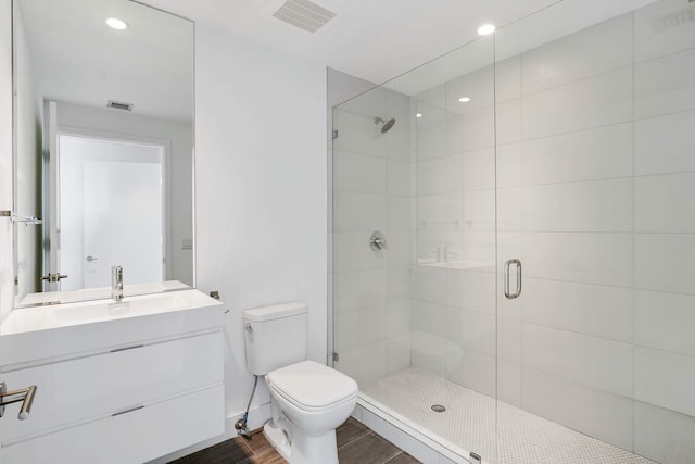 bathroom featuring walk in shower, vanity, and toilet