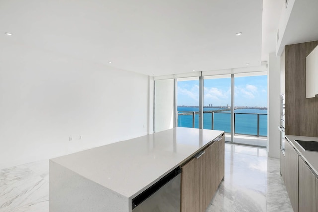 kitchen with a water view, wine cooler, expansive windows, a kitchen island, and black electric cooktop