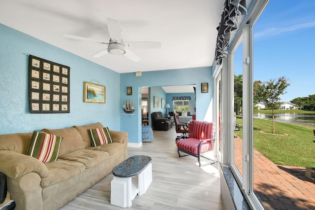 living room with plenty of natural light, ceiling fan, and light wood-type flooring