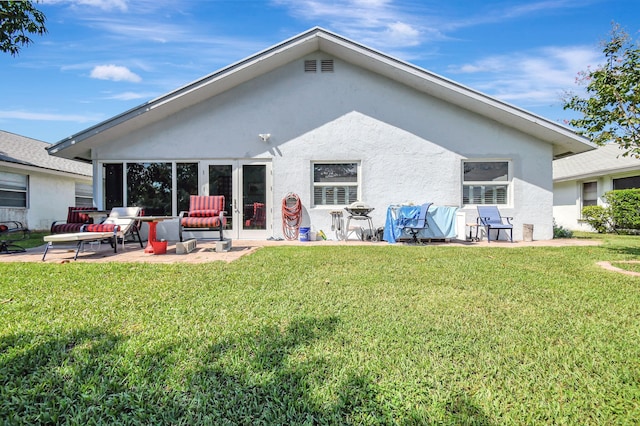 back of house with a patio and a lawn