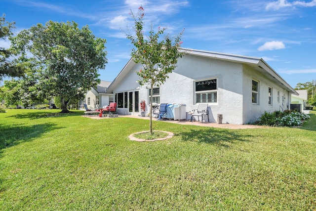 back of property featuring a lawn and a patio