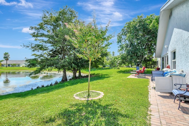 view of yard with a water view and a patio