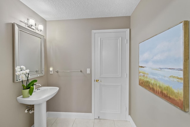 bathroom featuring sink, tile patterned floors, and a textured ceiling