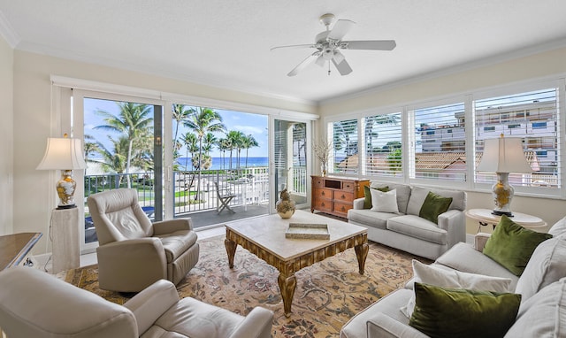 living room featuring a textured ceiling, ornamental molding, ceiling fan, and a water view