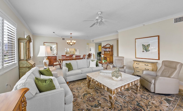 living room featuring ceiling fan with notable chandelier, ornamental molding, and a textured ceiling