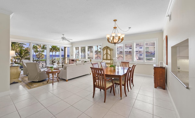 dining space with crown molding, ceiling fan with notable chandelier, light tile patterned floors, and a textured ceiling