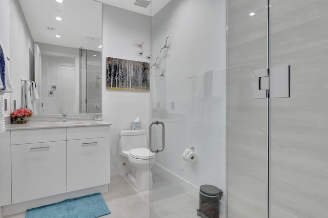 bathroom featuring vanity, a shower with door, and toilet