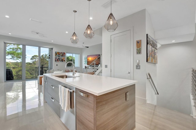 kitchen with stainless steel dishwasher, a kitchen island with sink, sink, and decorative light fixtures