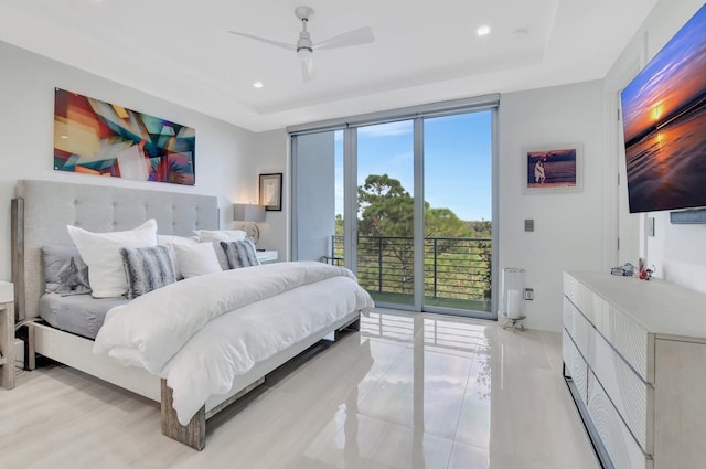 bedroom featuring access to outside, ceiling fan, and a tray ceiling