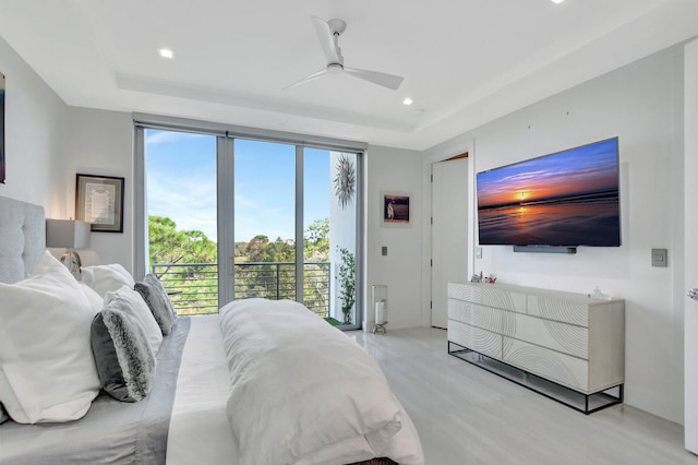 bedroom featuring ceiling fan, a tray ceiling, and access to outside