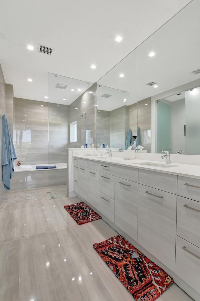 bathroom with vanity, separate shower and tub, and tile walls