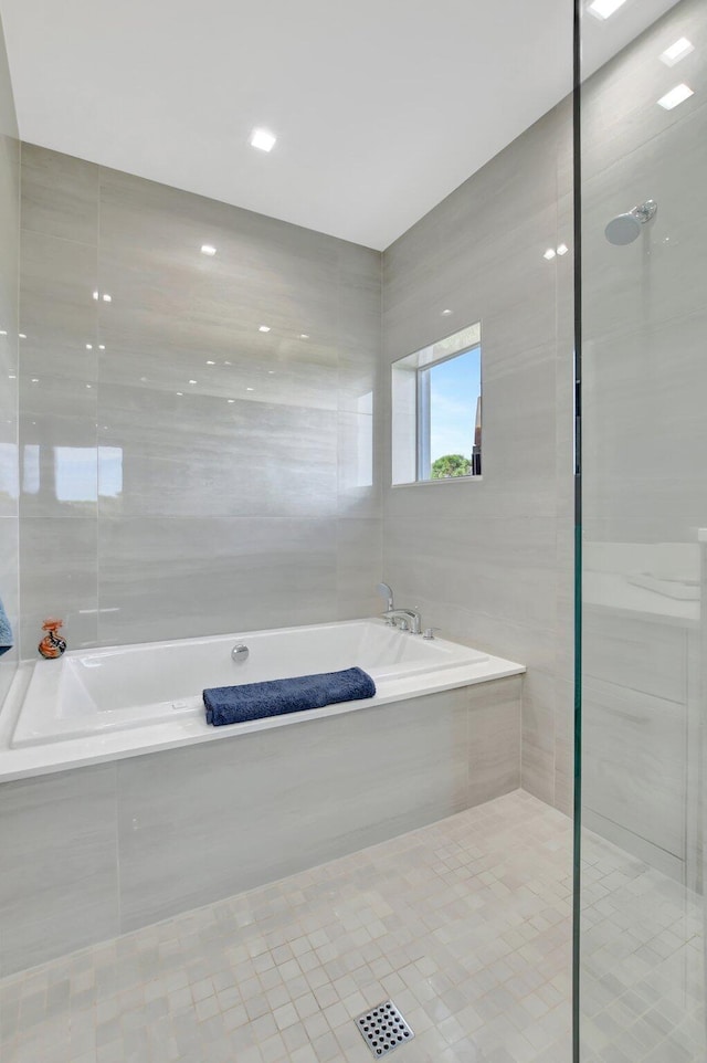 bathroom featuring tile walls, tile patterned floors, and plus walk in shower