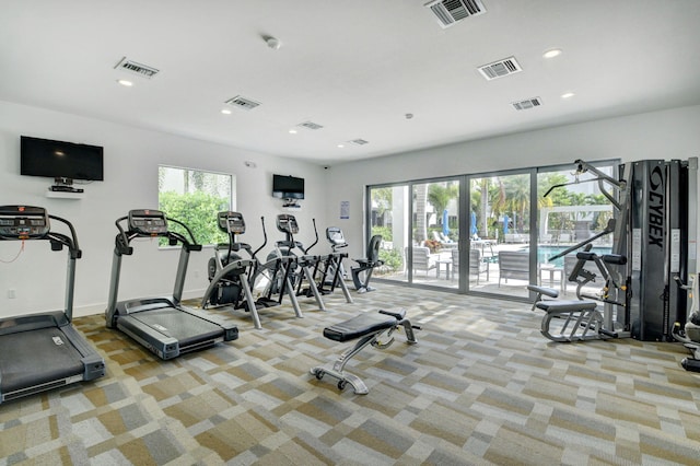 gym with a healthy amount of sunlight and light carpet