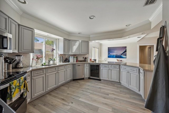 kitchen featuring light hardwood / wood-style floors, appliances with stainless steel finishes, gray cabinets, and sink