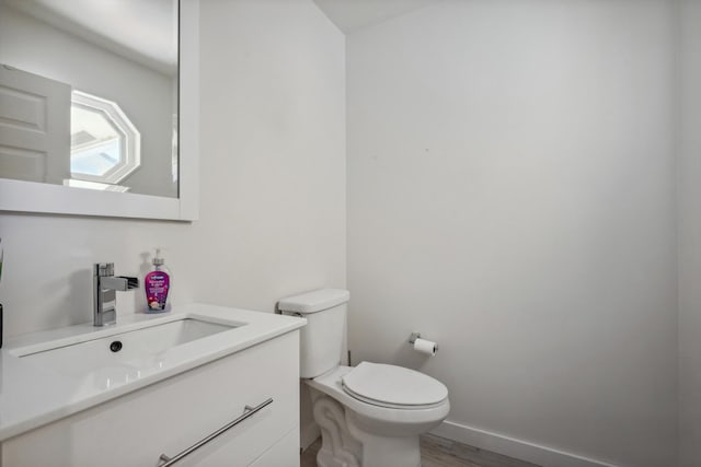 bathroom with vanity, wood-type flooring, and toilet