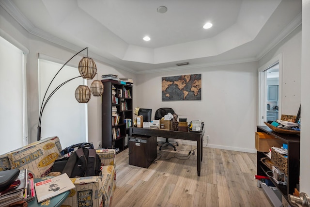 office area featuring a raised ceiling, crown molding, and light hardwood / wood-style floors