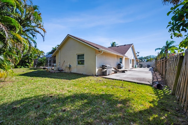 view of side of property with a yard, a lanai, and a patio area