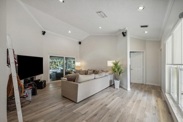 living room featuring high vaulted ceiling, ornamental molding, and light hardwood / wood-style floors