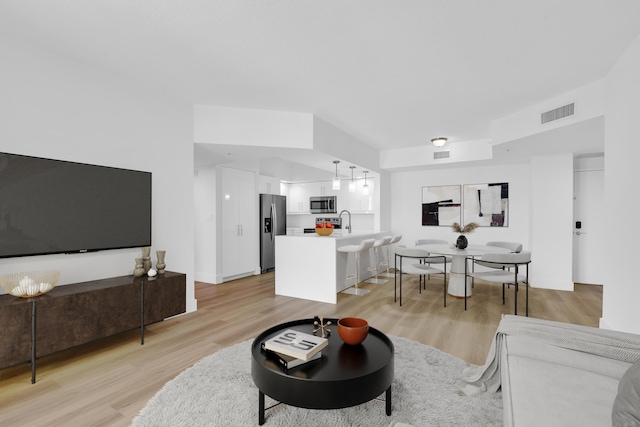 living area featuring visible vents and light wood-style flooring