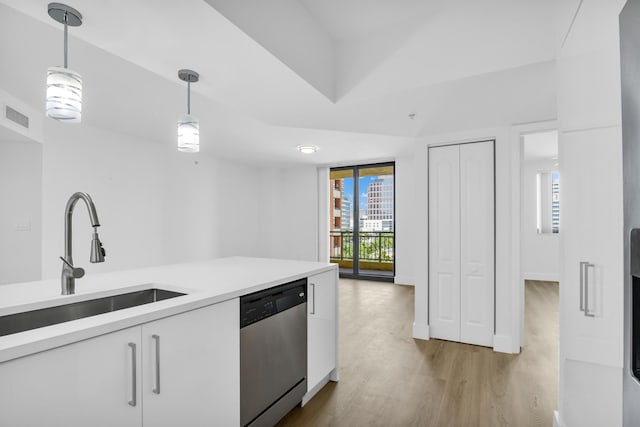 kitchen with white cabinets, light countertops, hanging light fixtures, and stainless steel dishwasher