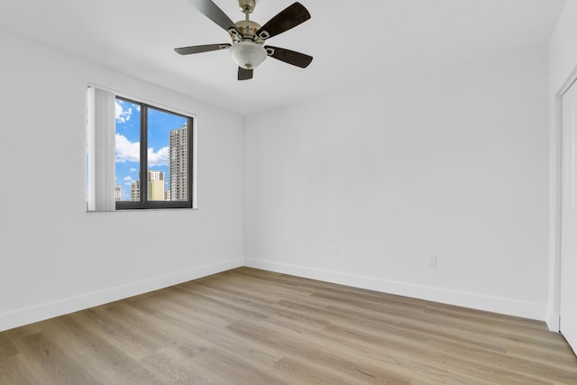 unfurnished room featuring light wood finished floors, baseboards, and a ceiling fan