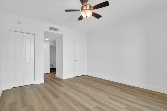 unfurnished bedroom featuring ceiling fan, a closet, and light hardwood / wood-style flooring